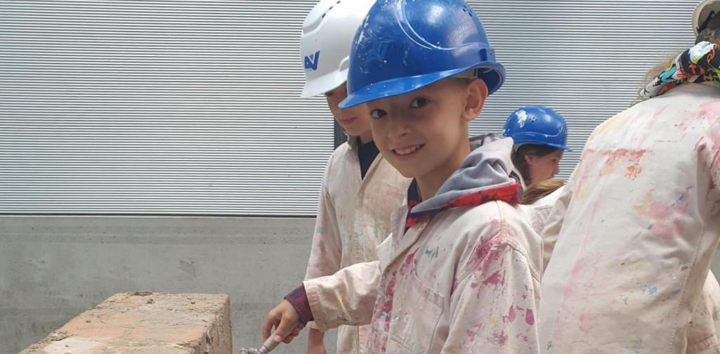 Verputz 2 Schüler verputzt eine Ziegelwand