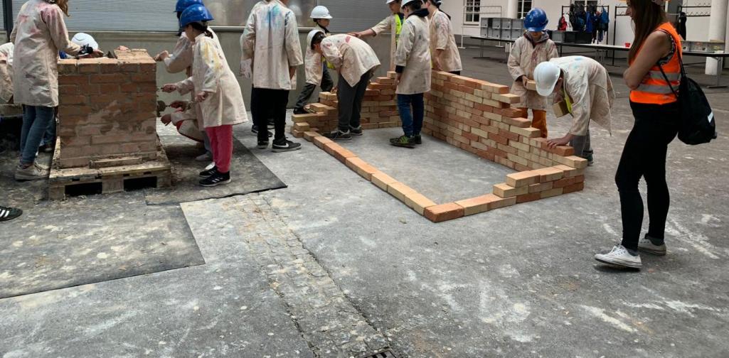 Trockenbauwand 1 SchülerInnen stellen mit Ziegelsteinen eine Trockenbauwand auf